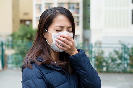 肺炎咳嗽摄影照片_亚洲的年轻女人生病，戴着口罩