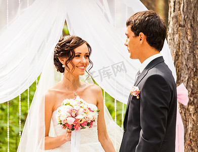 花朵结婚摄影照片_对夫妇结婚在户外举行婚礼仪式
