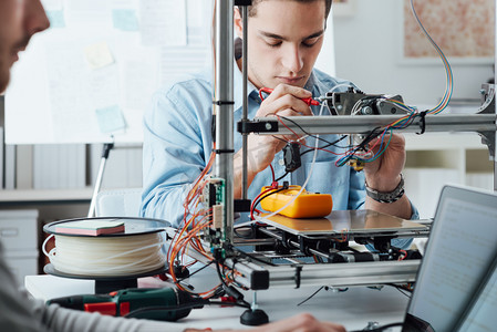 打印材料摄影照片_Students using a 3D printer