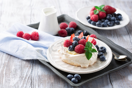 treat摄影照片_Pavlova cake with fresh summer berries