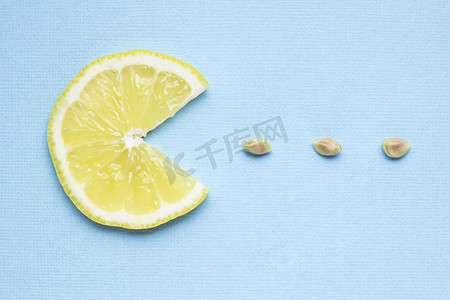 百胜餐饮集团 yum。在蓝色背景上吃种子柠檬片的创意概念照片.