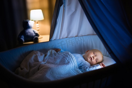 卧室黑暗摄影照片_男婴在晚上睡觉