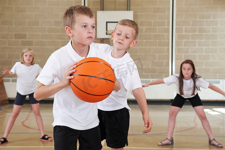 打篮球人摄影照片_小学生在体育馆打篮球