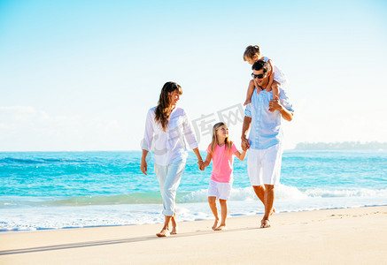 飞溅沙子摄影照片_在海滩上快乐的家庭