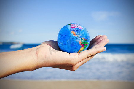 moving摄影照片_Young man with a world globe in his hand