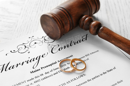金色的结婚戒指与判断婚姻合同，特写的木槌