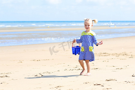 Little girl playing on the beach at summer