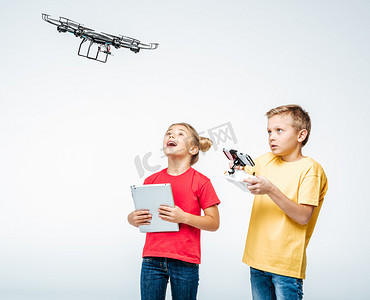 hexacopter摄影照片_孩子们使用数字平板和 hexacopter 无人机