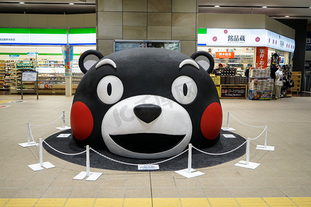 熊本-2017 年 5 月 9 日： Kumamon，黑熊吉祥物，在大尺寸放置在地上的主要火车站与便利店背景在熊本头