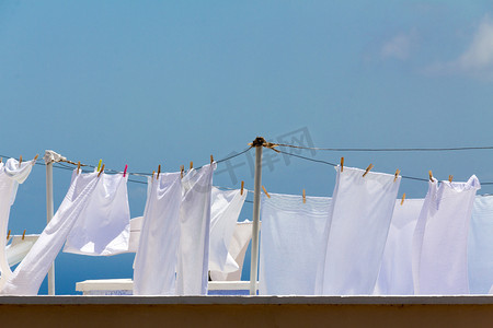 天猫新风尚白色摄影照片_在明亮清晰天烘干洗的床单上的绳索
