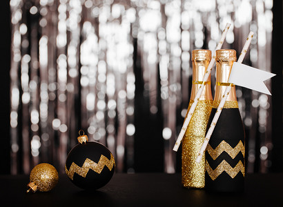 一年除夕装饰理念为您的家庭或方。金香槟和圣诞球以人字形花纹上闪亮的背景