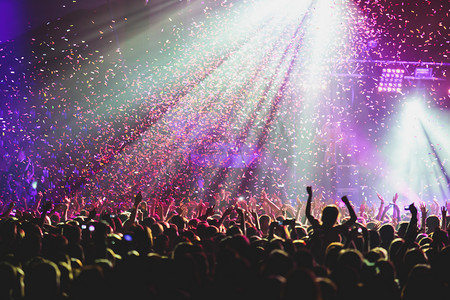 摇滚音乐会的视图显示在大音乐厅，与人群和舞台灯光，拥挤的音乐厅与场景的灯光，岩石显示性能，与人物剪影