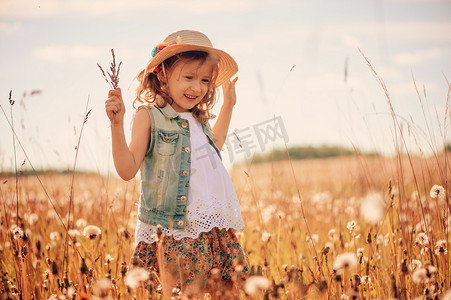 warm人像摄影照片_happy child on summer field, spending vacation outdoor, warm rural scene