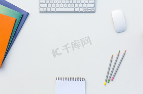 办公室白色表与计算机键盘鼠标颜色铅笔小册子和其他用品