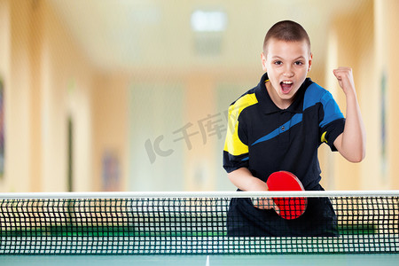 小男孩庆祝乒乓球的完美胜利