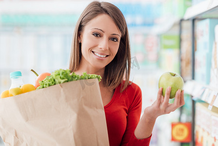 女人抱着购物袋的蔬菜