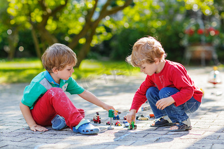 Two little boys playing with car toys