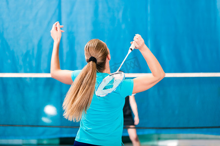 团队竞技摄影照片_在健身房，妇女打羽毛球运动