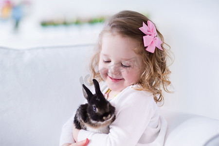 小女孩在玩与真实宠物兔