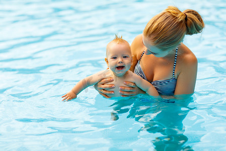 教游泳摄影照片_妈妈和宝宝在游泳池里游泳