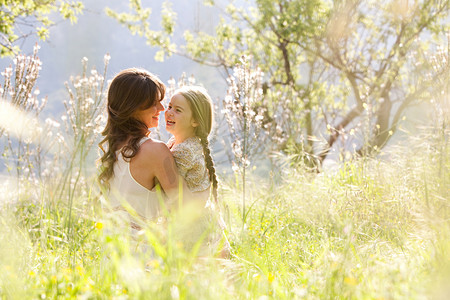 Mother and daughter hugging in a spring field