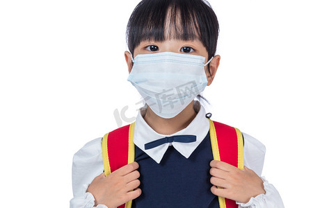 预防疾病知识摄影照片_亚洲中国学校与书包和戴着面具的女孩