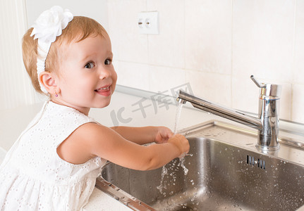 宝贝女孩洗她的手在浴室里