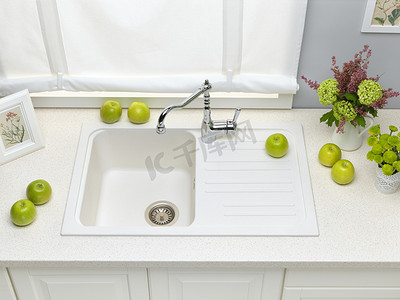 水龙头图片摄影照片_白色花岗岩厨房的水槽与混合器点击，鲜花和绿色的应用程序