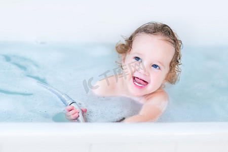 宝宝浴室摄影照片_与美丽的蓝眼睛和卷曲的头发洗澡宝宝