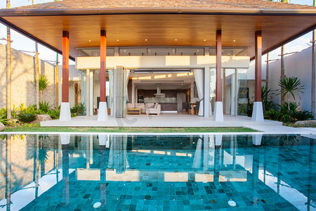 内部和外部设计的泳池别墅居住区、 绿化花园、 刹那游泳池、 木地板和包围棵椰子树的日光浴浴床的功能
