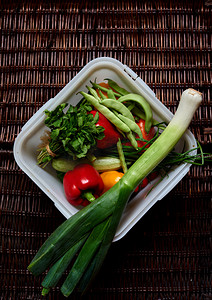 There are vegetables on a dark rattan table