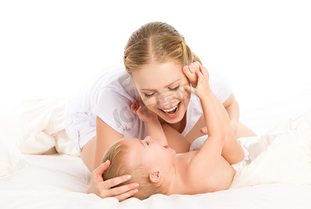 幸福的家庭母亲和婴儿玩玩，在床上笑