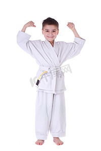 儿童跆拳道摄影照片_年轻的男孩战斗机在白色的和服
