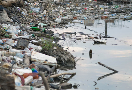 银行摄影照片_与塑料废物污染的河流.