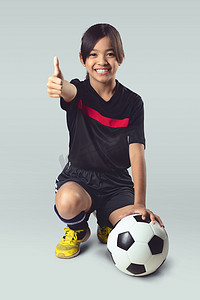 年轻的亚洲女孩抱着足球球