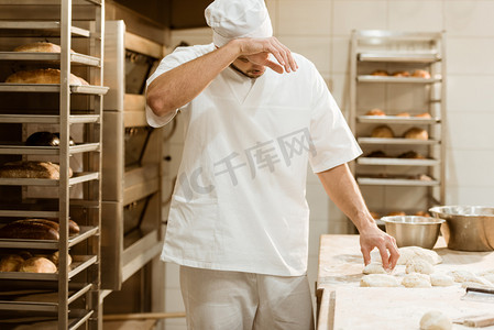 筋疲力尽的面包师与生面团在烘烤生产和擦汗工作