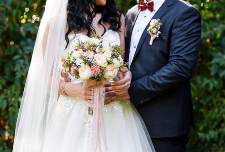 美丽的郁郁葱葱的新娘花束与花边丝带在新娘的手。幸福的新娘和新郎拥抱婚礼后, 自由空间。婚礼夫妇, 新婚夫妇, 自由空间