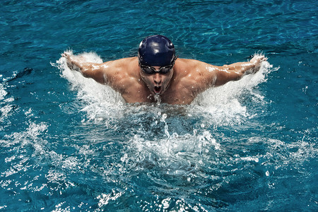swimwear摄影照片_Portrait of young man swimming in pool