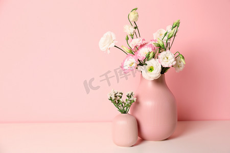 美丽的花朵在花瓶和空间的文本上的颜色背景。室内设计要素