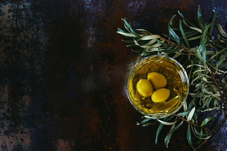 没有食欲摄影照片_大理石桌上的橄榄油和树枝的顶部视图