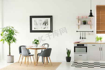 框架照片在一个开放的空间餐厅和厨房内部的白色墙壁现代, 木制家具和植物