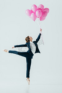 西装女实业家和芭蕾舞鞋持有粉红色气球, 在灰色隔离