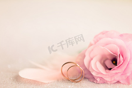 卡顿摄影照片_婚礼背景用金戒指，温和的花和光针