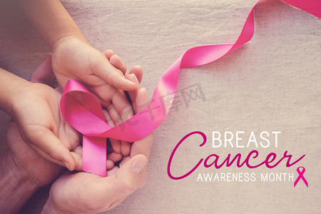 蒂芙尼丝带摄影照片_成人和儿童手持有粉红色丝带, 乳腺癌意识, 腹部癌症意识, 10月粉红色概念 