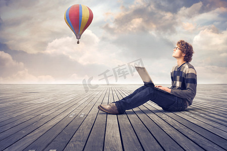 a梦摄影照片_Young man on  floor using a laptop