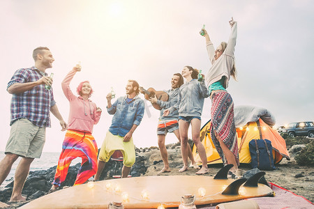 快乐的朋友跳舞和乐趣在露营地做一个海滩派对--年轻人在野营时笑着喝啤酒, 旅行, 度假, 生活方式的概念