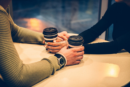 在咖啡馆里牵着手和喝咖啡的情侣