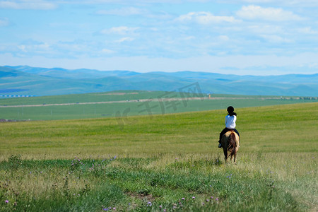 蒙古骑马摄影照片_骑着马在草原