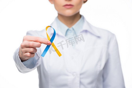 女医生持有蓝色和黄色丝带为唐综合症日隔离白色