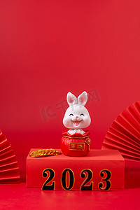 兔年微信公众号首图摄影照片_2023新年小兔子红色背景摆放摄影图配图